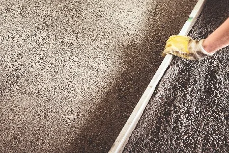 Person glättet Kies mit Richtlatte